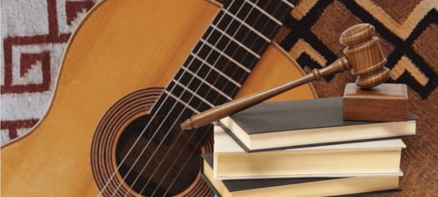 Imagem de um violão e martelo jurídico em cima de livros