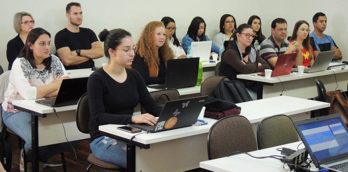 Imagem de alunos da Pós-Graduação UniSecal. Eles estão dentro de uma sala de aula e sentados em cadeiras.