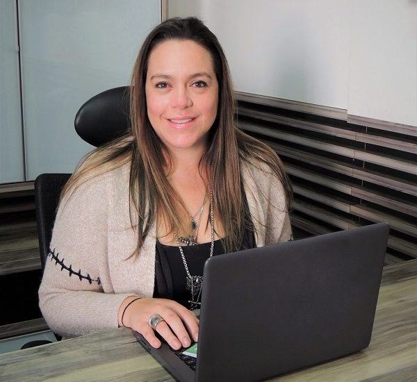 #PraCegoVer: Imagem da Reitora da UniSecal, Isaura de Andrade Aguiar. Ela está usando um computador portátil.