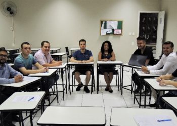 #PraCegoVer: Foto mostra sete alunos e um professor sentados. Eles estão em círculo, dentro de uma sala de aula